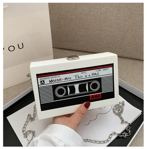 Detail of creative cassette tape clutch bag with metallic chain strap and printed graphics