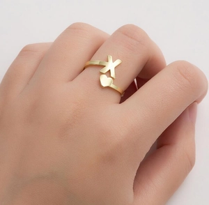 Detailed shot of golden alphabet X and heart adjustable open ring on model hand