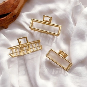 Three-piece set of gold metal claw clips in minimalist rectangular and striped designs