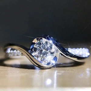 Macro shot of silver ring featuring a large round zircon stone with brilliant cut detail