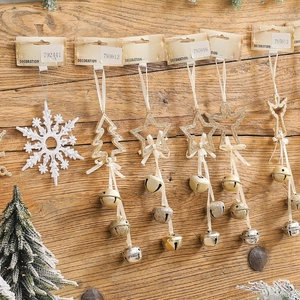 Christmas decoration pendants featuring snowflakes and stars with metal bells on wood