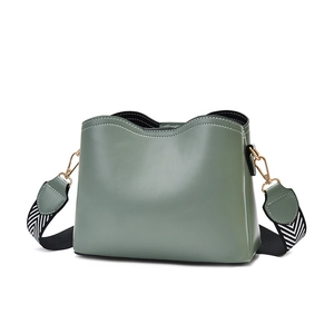 Minimalist sage green shell handbag with geometric patterned strap and gold hardware