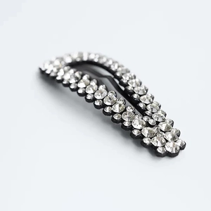 Pinza para el pelo con estrases, base de metal negro y cristales brillantes para peinados chic.