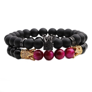 Detail von matten Tigerauge-Perlen und Kronen-Charm auf dem schwarzen und rosa Armband-Set
