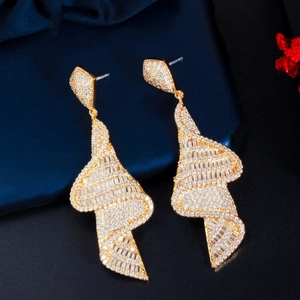 Macro detail of gold geometric spiral earrings with micro-pave white zircon crystals
