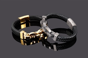 Détail de bracelets en cuir noir tressé avec fermoirs magnétiques en or et argent