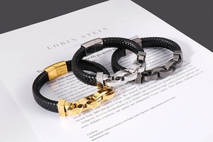 Détail de bracelets en cuir tressé avec des fermoirs en acier inoxydable or et argent