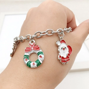 Detail eines verstellbaren Silberarmbands mit Emaille-Anhängern von Weihnachtsmann und Kranz