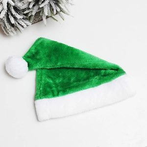 Green plush Christmas hat with white faux fur trim and pine needle decoration on white backdrop