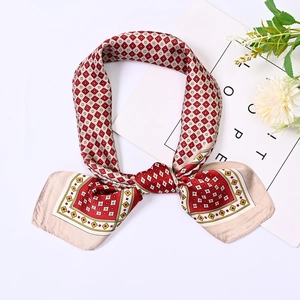 Detail view of 70cm geometric lattice silk scarf tied in a bow with red and beige patterns