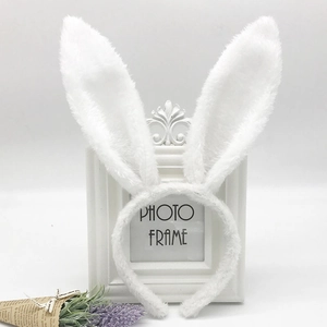 Detail of white plush rabbit ears headband with sequins in a clean minimalist aesthetic