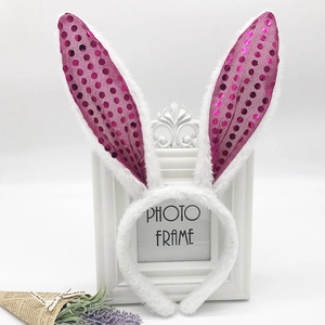 Detail of plush white rabbit ear headband featuring vibrant rose red sequins decoration