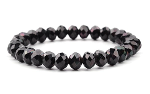 Macro shot of faceted black crystal glass beads bracelet with rainbow luster on white base