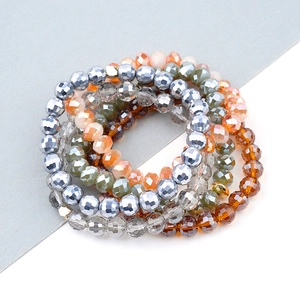 Macro shot of multi-layer faceted crystal beads and silver metal charms on a tiered bracelet