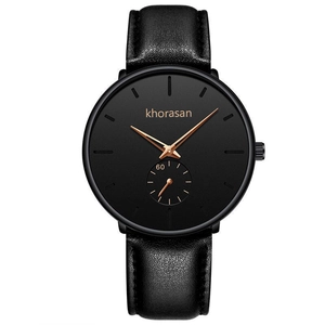 Macro shot of black minimalist watch dial with rose gold hands and small sub-dial