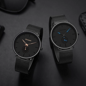 Detail of minimalist mesh strap watches with rose gold and blue accents on matte dials