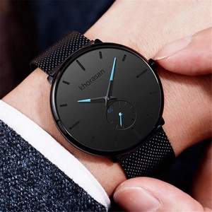 Detail of Khorasan men's watch with black mesh strap and blue hands on a business suit