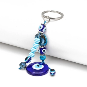 Blue Evil Eye keychain with metal palm and glass beads on a clean white background