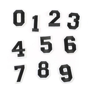 Close-up of black embroidered number patches with white borders for clothing
