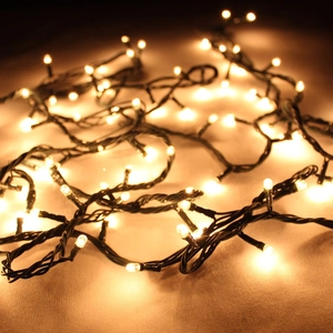 Copper wire LED Christmas fairy lights with warm white glow on a fabric background