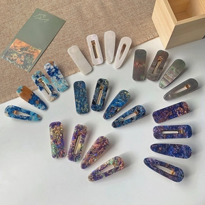 Detailed top view of marble textured acrylic hair clips in geometric shapes