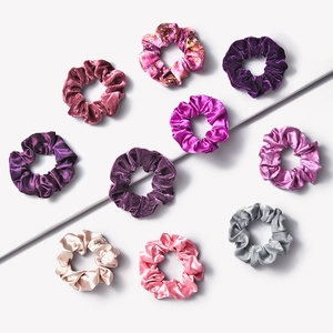 Set of 9 velvet and satin scrunchies in purple and pink tones on a clean white background