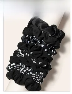 Close-up of assorted black fabric scrunchies with polka dots and floral patterns