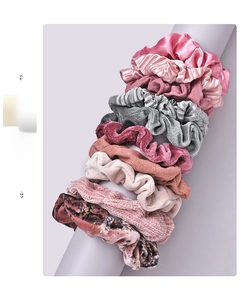 Detail of assorted velvet and satin scrunchies in pink, grey and burgundy hues