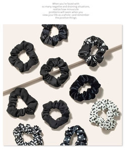 Set of 10 assorted hair scrunchies in black and white patterns on a beige background