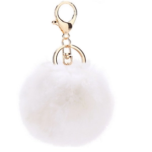 Macro detail of white faux fur ball keychain with polished gold lobster clasp and ring