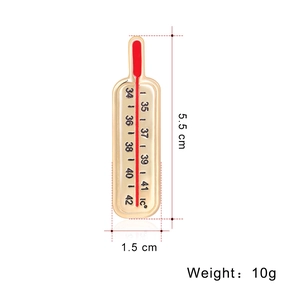 Détail montrant les dimensions d'une broche thermomètre en émail rouge et or poli