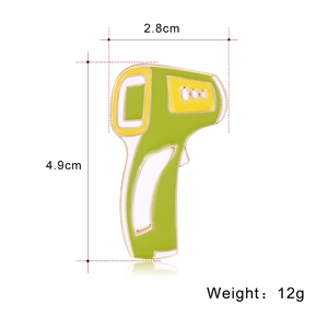 Détail d'une broche thermomètre en émail vert montrant les dimensions 2,8cm x 4,9cm et 12g