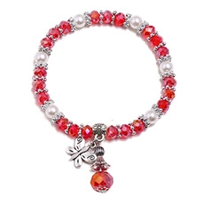 Detail of beaded elastic bracelet with red crystal beads, white pearls and silver butterfly charm