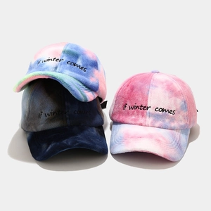 Detailed view of colorful tie-dye plush baseball caps with If winter comes embroidery