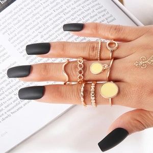 Detailopname van een gouden metalen ringenset met diverse minimalistische stijlen op de hand