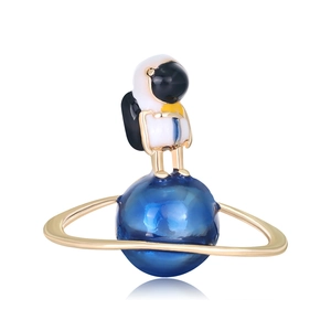Luxurious blue planet and astronaut brooch with shiny enamel finish on white background