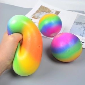 Rainbow stress relief balls in squeeze action on grey surface with magazine backdrop