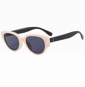 Detail of cream cat-eye sunglasses featuring black temples and silver metal accents