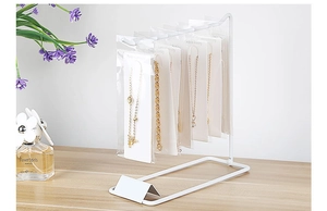 Detail of white metal jewelry display stand with hooks for necklaces and earrings