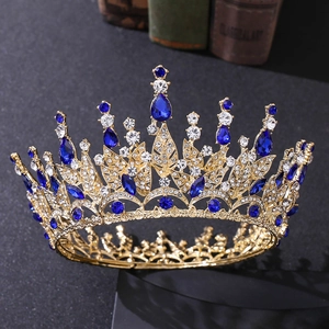 Detail of golden leaf crown featuring blue teardrop gemstones and sparkling rhinestones