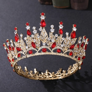 Detailed view of golden leaf crown featuring red crystals and clear rhinestones