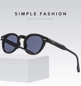 Detail of black bold frame sunglasses with blue lenses and metallic rivet accents