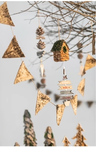 Macro shot of rustic wooden Christmas pendant with pine cone and jute rope on branches