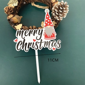 Detail showing acrylic Christmas gnome cake topper with Merry Christmas text on dark background