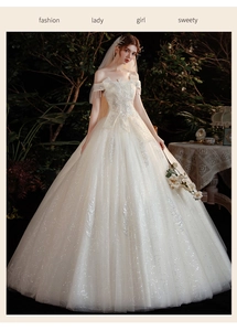 Détail de la robe de mariée blanche à paillettes avec broderie plume et voile
