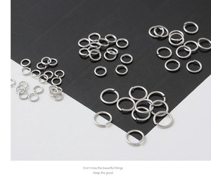 Macro shot of silver open jump rings for DIY jewelry making displayed on a split background