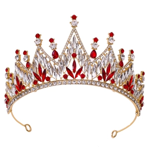 Close-up of golden bridal crown with red teardrop crystals and clear rhinestones