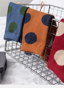 Close-up of colorful vintage polka dot knit cotton socks displayed on a metal rack