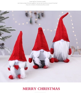 Close-up of three plush Christmas gnomes with knitted hats and warm LED lights