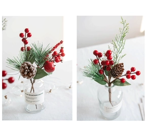 Detail of Christmas spray with red berries pine cones and needles in a glass vase